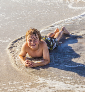 躺在沙滩上，享受阳光的男孩