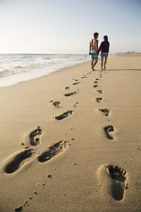 年轻的夫妇在海滩散步
