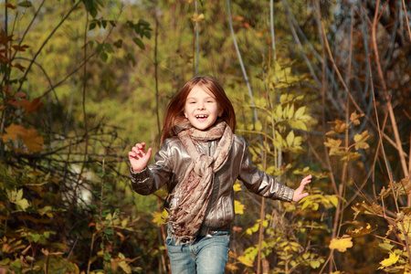 孩子在秋天的树林中运行