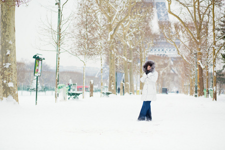 美丽的年轻女子在巴黎的一个下雪天