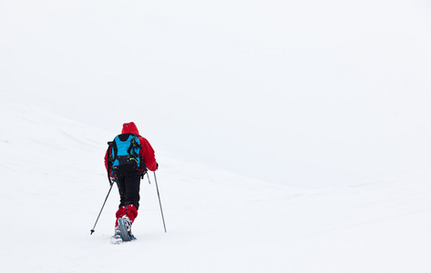 男孩徒步在山与雪鞋