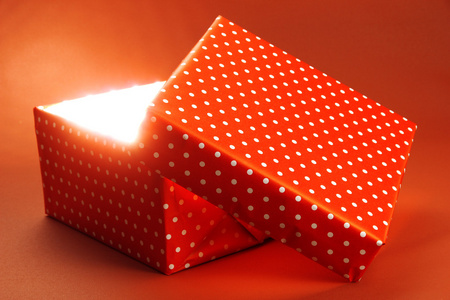 礼品盒与明亮的光，就在红色背景上