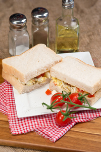 新鲜鸡蛋和番茄对白色三明治在乡村厨房设置