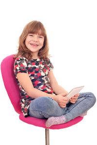 小女孩坐在椅子和 tablet pc 一起玩
