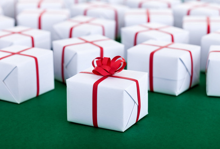 在白色的礼品盒绿色表面上很多礼物