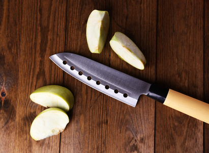 厨刀和青苹果，木制的背景上