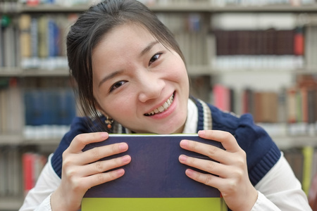 她的下巴搁在教科书上的学生图片