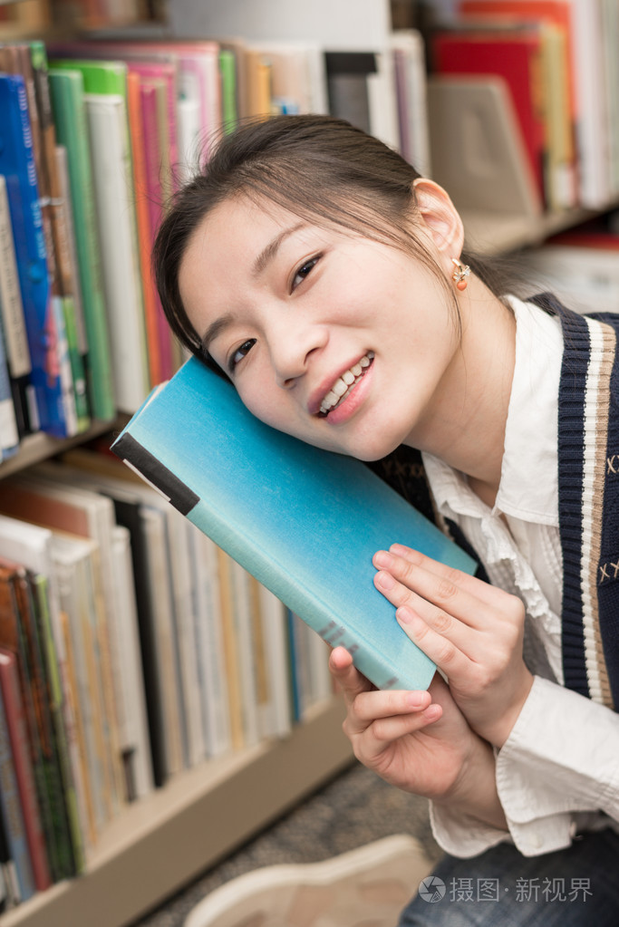 女孩捧着一本书,她的脸颊