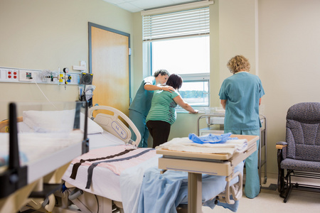 护士安慰孕妇在医院病房的窗户