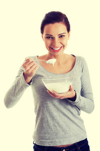 一个年轻的休闲女人在吃酸奶。