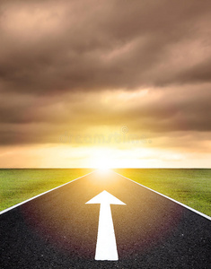 前进路上沥青路上的前进箭头和夕阳照片