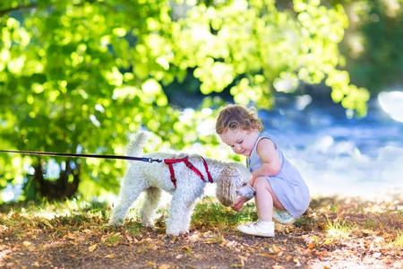 可爱的小女孩和小狗在河边