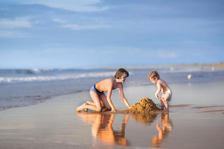 有趣的小女孩和她弟弟在海滩上