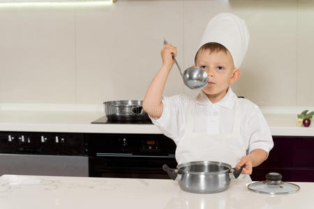 小男孩厨师品尝他的食谱