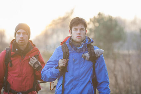 年轻的男性徒步旅行者在田野里望向别处