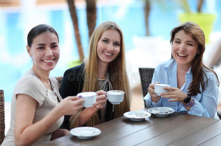 年轻女子在户外咖啡馆喝咖啡