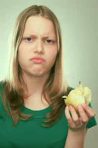 一个不快乐的少女拿着苹果的画像