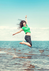 快乐的女人在海水中跳跃
