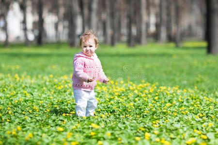 可爱的小女孩在阳光明媚的春天公园里玩耍