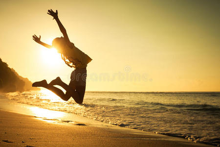 在海滩上跳跃的少女