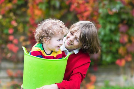 两个孩子拿着洗衣篮在花园里玩耍