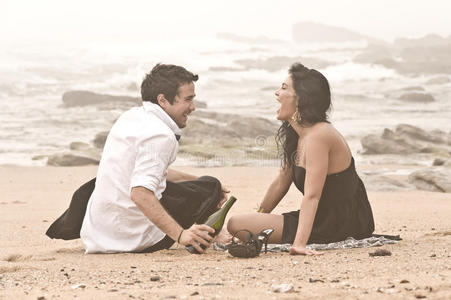 年轻迷人的情侣在沙滩上笑