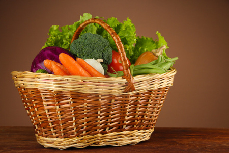 不同的蔬菜在篮子里上棕色背景表格