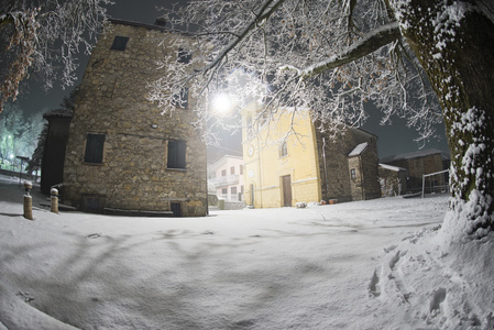 同时下雪的一座教堂的夜景