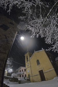 同时下雪的一座教堂的夜景