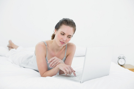 随便的女人在床上使用笔记本电脑