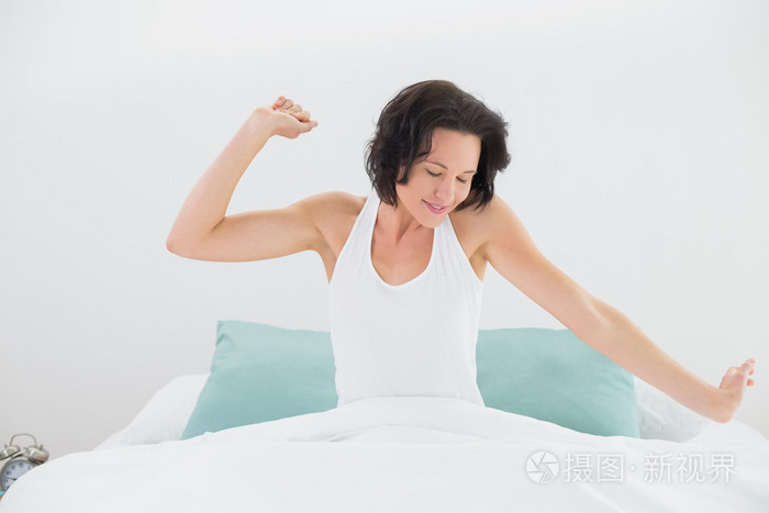 伸胳膊躺在床上的年轻女子