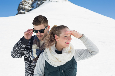 夫妇在暖和的衣服在雪的山