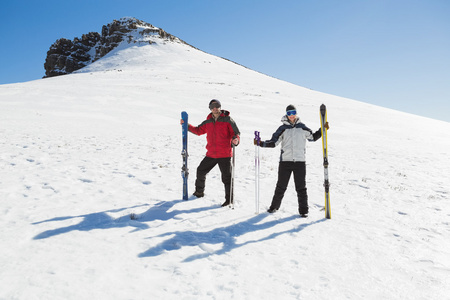 一对夫妇与站在雪上滑雪板的全长