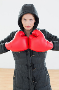 严重的女人，在红色的拳击手套和黑色罩在健身斯图