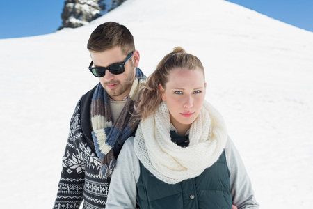 夫妇在暖和的衣服在雪的山