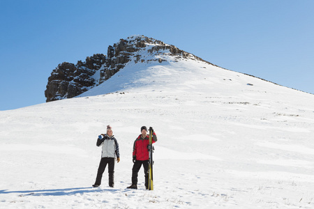 一对夫妇与站在雪上滑雪板的全长
