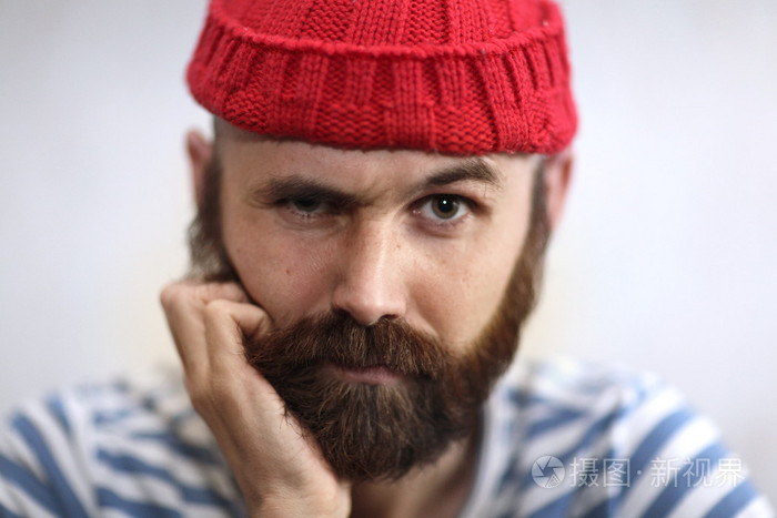 一个有趣的人,留着胡子,读的帽子的肖像