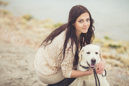 美丽的年轻女子，在海面上玩狗的肖像