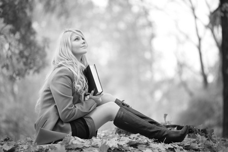 片秋色的公园里看书的女孩