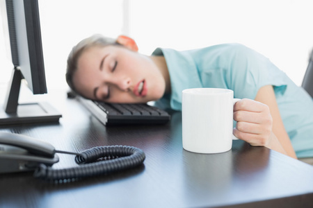 打瞌睡女坐在她在转椅上打瞌睡的可爱女商人照片