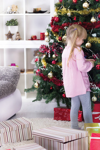 小女孩在家里装饰圣诞树