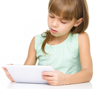 年轻的女孩正在学习时使用平板电脑