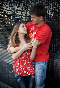 学生情侣拥抱在墙上的街道
