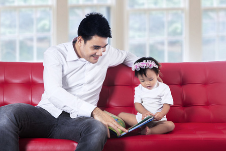 年轻的父亲和他的宝宝读故事书图片