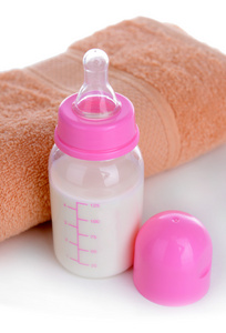 婴儿奶瓶与牛奶和毛巾的特写
