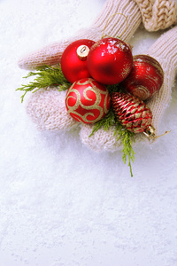 女手连指手套在彩色背景上的圣诞树球