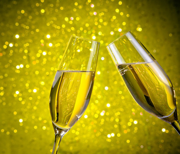 与金色的泡泡，黄色的灯景背景上的香槟酒一双