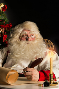 圣诞老人坐在家里和写一封信