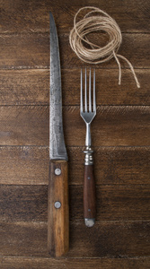 老式的刀和叉在木制的背景上