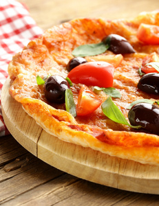 意大利的比萨饼，橄榄，西红柿在木板上